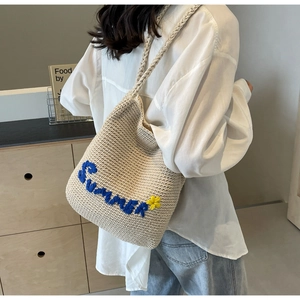 Détail du sac fourre-tout tissé beige avec broderie Summer bleue et motif de fleur jaune