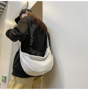 Detailed back view of a white crescent crossbody bag with nylon wrinkle texture on a model