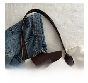 Détail des poignées en cuir marron et du tissu oxford sur un grand sac fourre-tout