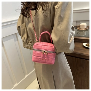 Détail du mini sac bandoulière matelassé rose avec chaîne dorée sur un mannequin
