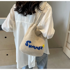 Détail du sac cabas beige tissé avec broderie Summer bleue et petite fleur jaune