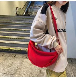 Detail of red crescent nylon crossbody bag showing spacious moon shape and wrinkled texture