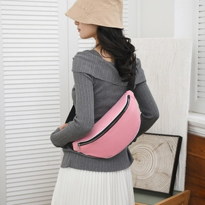 Detail view of a pink waterproof chest bag with a black metal zipper and adjustable strap