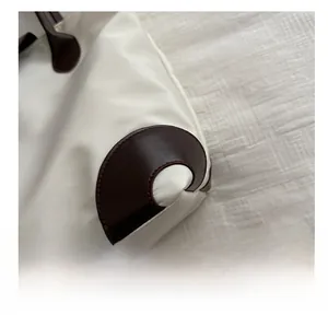 Détails du tissu oxford et des coins en cuir marron renforcés sur le grand sac cabas