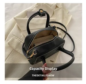 Interior view of black PU leather handbag with white stitching and spacious single compartment