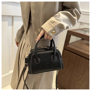 Detail of black PU leather Boston bag featuring white contrast stitching and lady bags logo