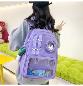 Detail view of purple nylon ita bag with clear window pockets and cute accessories