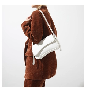 Detail of white lychee texture PU leather shoulder bag with gold metal hardware