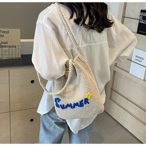 Détail du sac cabas tissé crème avec broderie Summer et petite fleur au crochet jaune vif