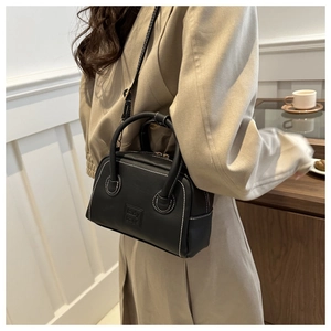 Detail of a black Boston bag featuring white contrast stitching and lady bags embossing