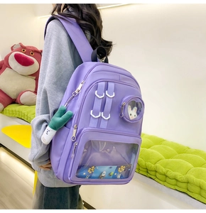 Detail view of purple Ita bag showing transparent PVC window for badges and accessories