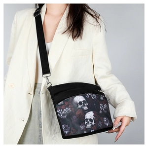 Gros plan sur le sac bandoulière en tissu oxford noir avec imprimé crâne et fleurs