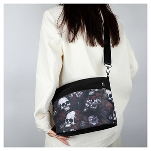 Détail du sac bandoulière avec imprimé crâne et fleurs violettes sur tissu oxford noir