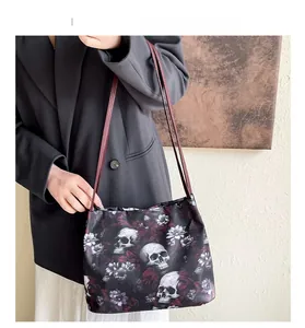 Dettaglio di una borsa tote gotica con stampa di teschio e fiori su tessuto nero