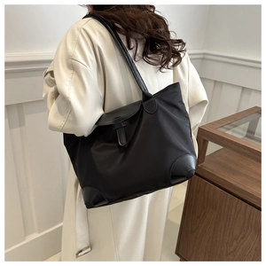 Sac fourre-tout noir moderne en nylon présenté dans un décor intérieur minimaliste