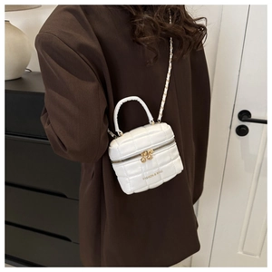 Détail du mini sac à main blanc matelassé avec double fermeture éclair et texte fashion