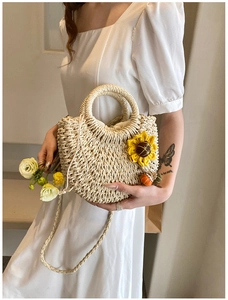 Detail of woven straw crossbody bag with floral sunflower accent and drawstring lining