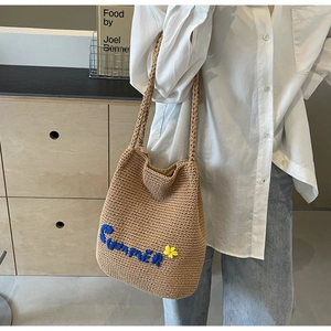 Détail du sac cabas en paille avec broderie Summer bleue et petite fleur jaune décorative