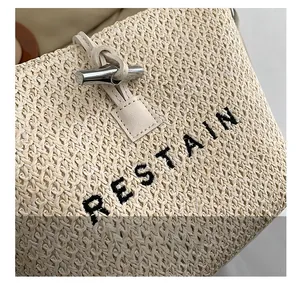 Gros plan sur la texture en paille tressée avec broderie RESTAIN et boucle argent
