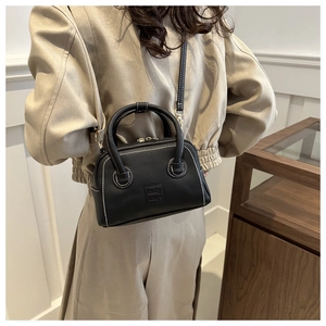 Detail of vintage black handbag with white contrast stitching and lady bags embossing