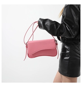 Detailed view of pink lychee grain PU leather handbag with asymmetrical wavy flap design