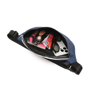 Detail view of a spacious dark blue canvas crossbody bag with dual-way zippers and wide strap