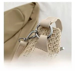 Détails de la quincaillerie argentée et de la bandoulière en cuir du sac tissé