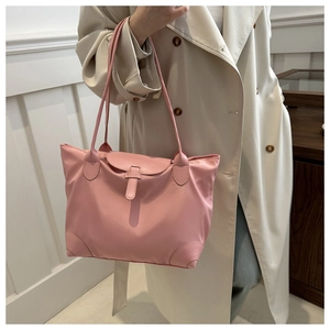 Détail du sac cabas en nylon brillant rose avec fermeture à boucle et finitions en cuir