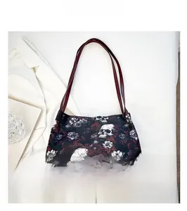 Dettaglio della stampa teschio e fiori gotici su una grande borsa tote nera con manici