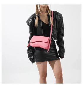 Detail of pink PU crossbody bag with wave-shaped bottom and pebble grain leather texture