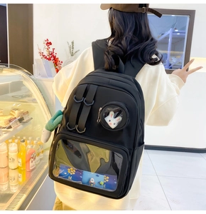 Detail of black nylon ita bag with transparent windows and plush rabbit toy decoration
