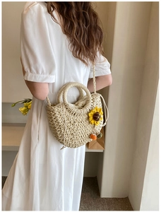 Close-up of a handmade woven straw bag featuring sunflower decor and a drawstring inner pouch