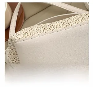 Détail des coutures fines et de la texture tressée du sac à main beige en paille et cuir