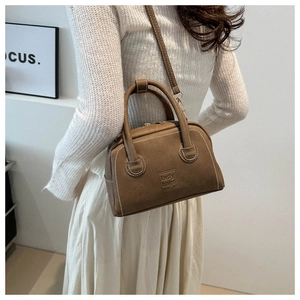 Detail of brown PU leather boston bag with lady bags embossing and adjustable strap