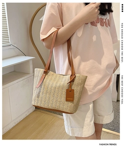Detailed shot of straw tote bag with brown leather handles and a fashion hangtag