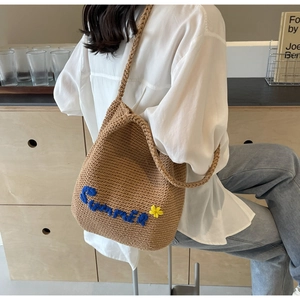 Détail d'un sac bandoulière marron tissé main avec broderie Summer et fleur décorative