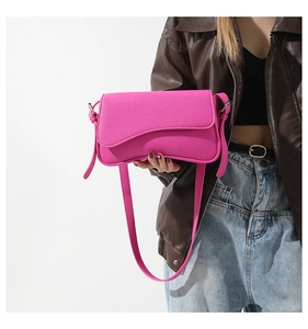 Fashionable pink pebbled leather crossbody bag with silver hardware on a model