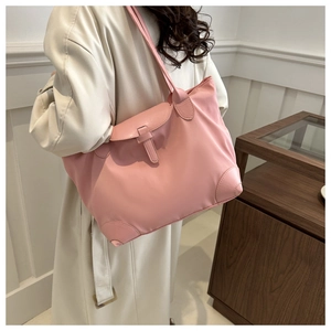 Détail du cabas en nylon rose avec coins renforcés en cuir et sangle à boucle élégante