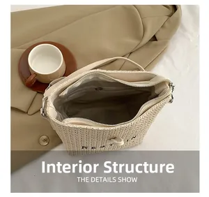 Détail d'un sac bandoulière tissé montrant le compartiment principal et la poche zippée