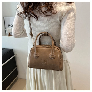 Detail view of vintage brown PU leather square bag with contrast stitching and top handles