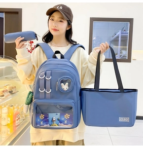 Detailed view of the 3-piece blue nylon backpack set with a clear window and plush charms