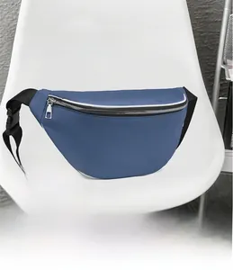 Detail view of a blue canvas chest bag with silver zipper on a white chair in a room