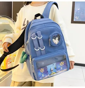 Detail of blue nylon backpack featuring a clear window with a cute plush rabbit charm