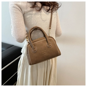Detailed close-up of brown PU handbag with white stitching and lady bags embossed logo