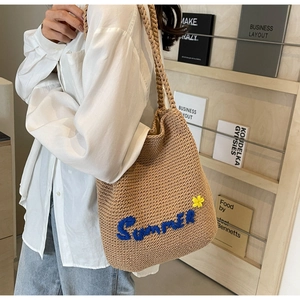 Gros plan du sac cabas tissé avec broderie Summer et détails floraux sur un mannequin