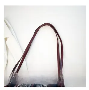Dettaglio dei doppi spallacci bordeaux su una borsa tote con teschi e fiori gotici