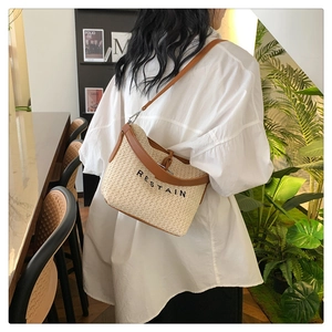 Detail shot of the woven straw texture and leather trim on the Restain shoulder bag