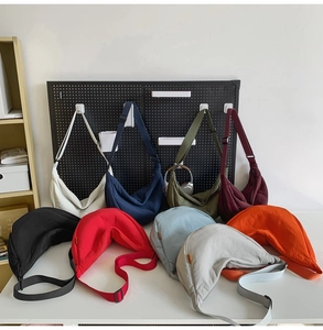 Selection of colorful nylon crescent crossbody bags showing various hues and adjustable straps