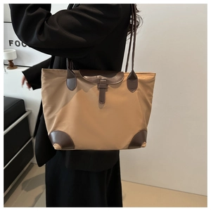 Détail du sac cabas en nylon kaki avec bordure en cuir marron et matériau haute densité