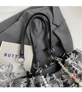 Detailaufnahme der gewebten Karo-Tragetasche mit Lederriemen und eleganter Kette